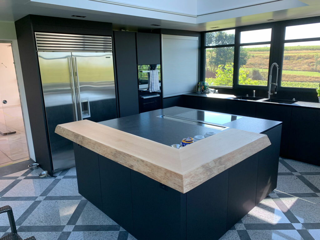Réalisation d'un cuisine fenix mat et sol en granit avec vue sur le jardin